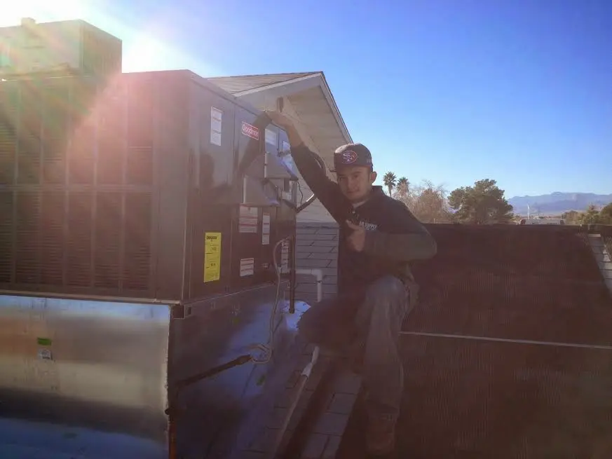HVAC technician performing Boiler Repair on a rooftop unit in Weston